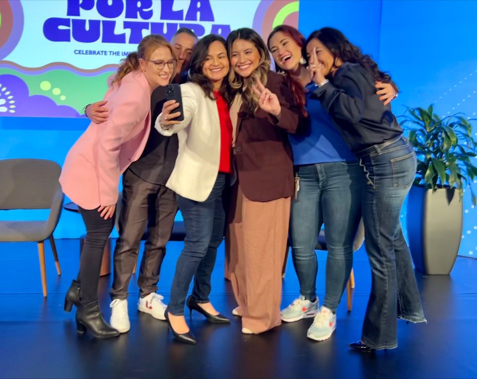 Adelante team members taking a group selfie on stage