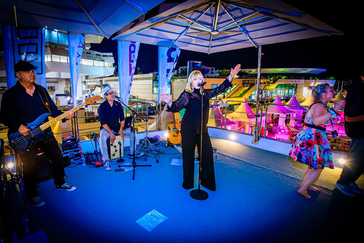 Live band performing on the yacht deck under blue stage light at Cannes Lions 2026