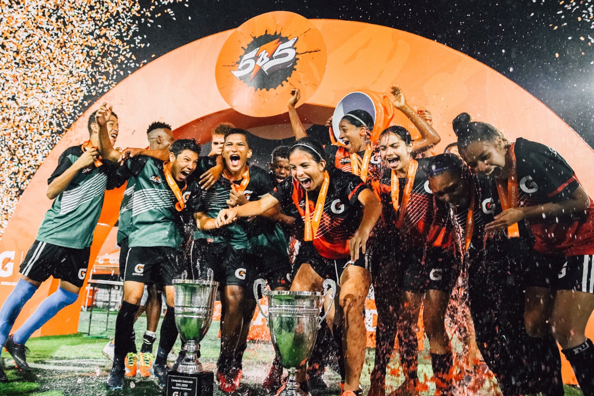 Young players celebrating under confetti with the Gatorade 5v5 trophies at the national final