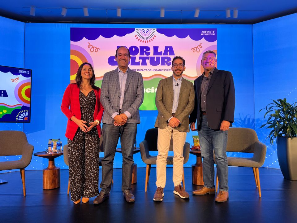 Four speakers standing together on stage after their panel