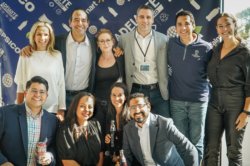 Team members posing in front of the PepsiCo and Walmart Adelante backdrop