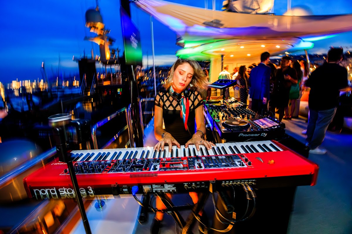 Keyboardist performing at dusk over the Port de Cannes marina