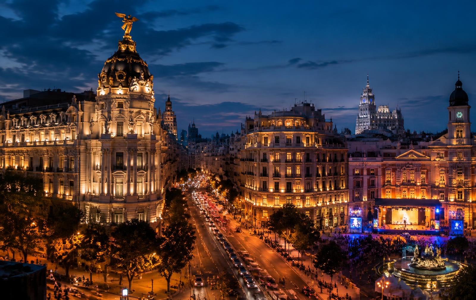 The Gran Via in Madrid at blue hour with classical buildings lit in gold