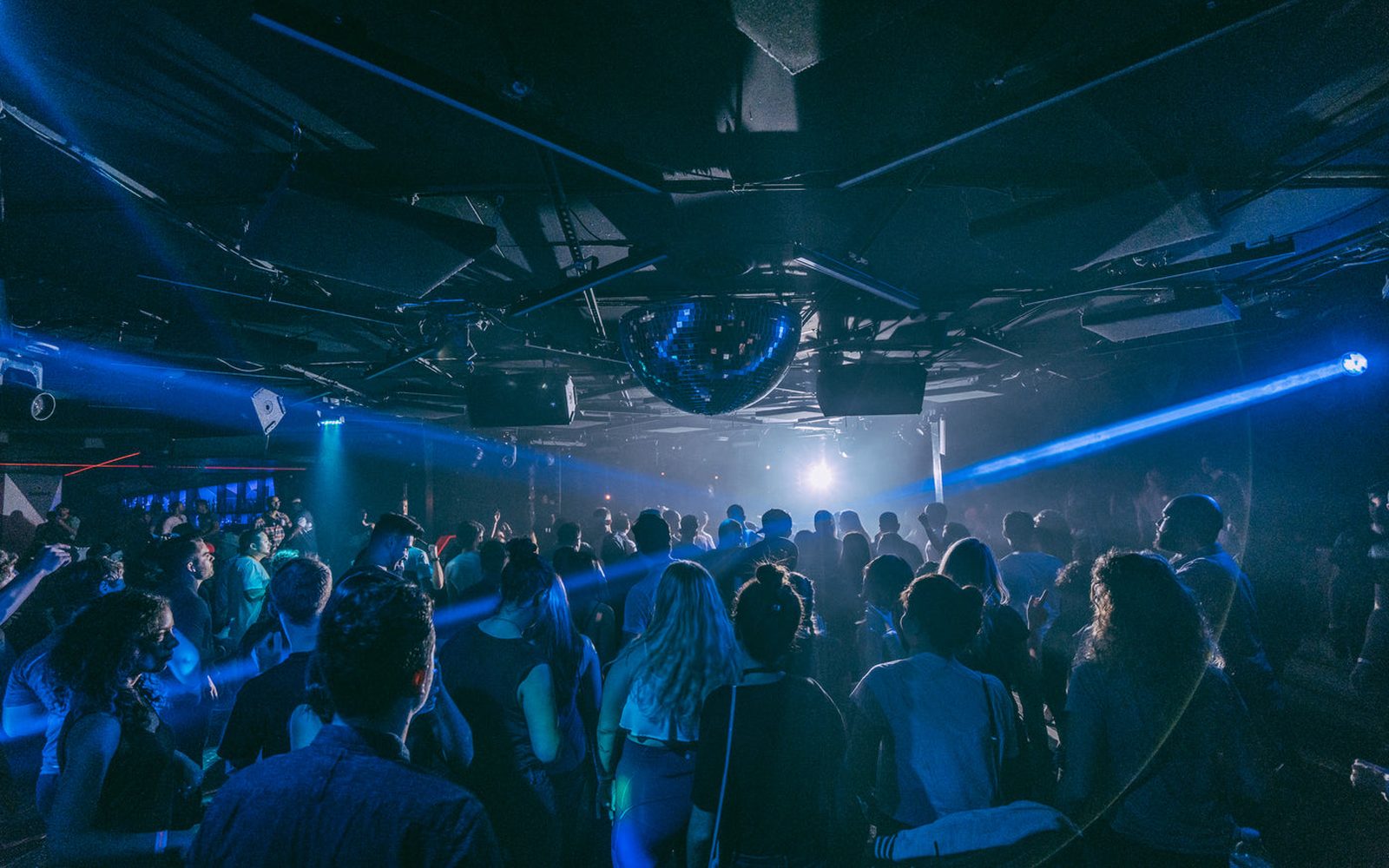 Crowd at a Miami nightlife venue washed in electric blue light